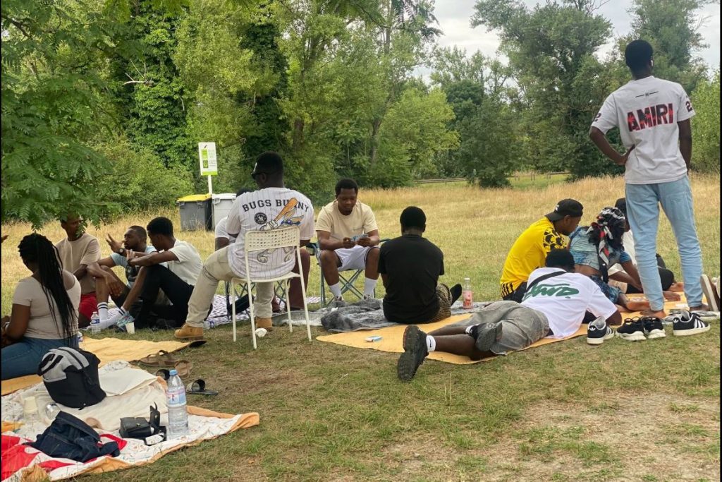 Des jeunes jouant aux cartes à l'occasion du Barbecue annuel AJEGUIR 2025 au parc de Miribel-Jonage Rhône